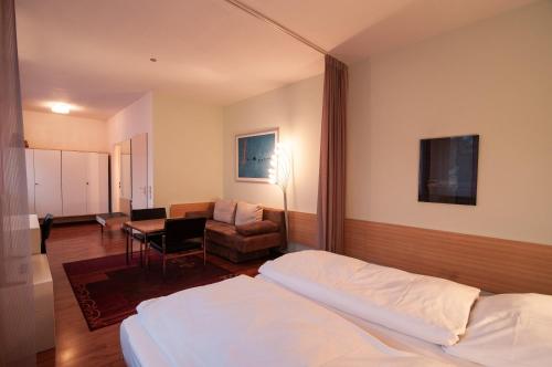 a bedroom with a bed and a chair and a desk at Hotel Bären Trossingen in Trossingen