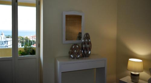 a room with a table with a mirror and a window at Funchal Window by Homie in Funchal