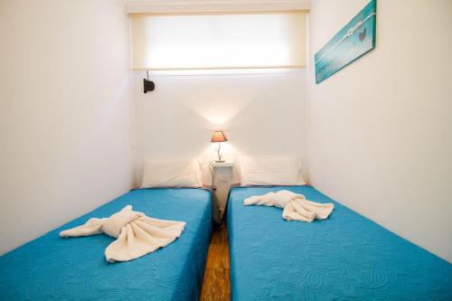 2 Betten in einem kleinen Zimmer mit Handtüchern darauf in der Unterkunft Flatguest PR Beach - Terrace + Garden + 24H in Mogán