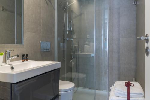 a bathroom with a shower and a sink and a toilet at Capim Dourado Apartments Cedofeita in Porto