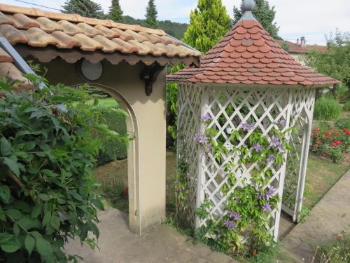 a white gazebo with a gate and flowers at Gîte de la fontaine in Saint-Rémy-la-Calonne