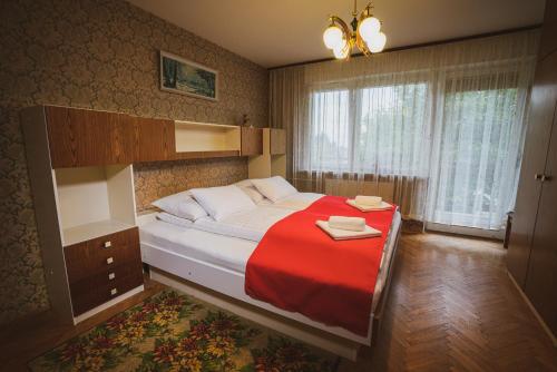 a bedroom with a large bed with a red blanket at Apartmaji Retro in Spodnje Gorje