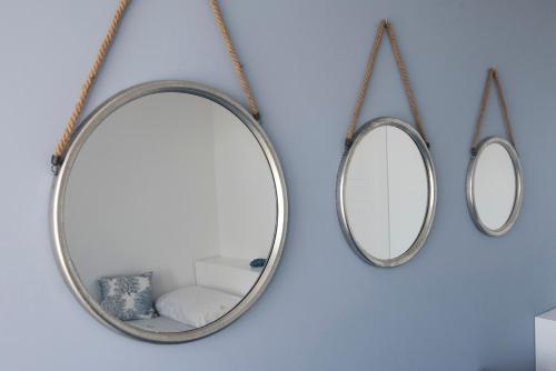 two mirrors hanging on a wall with a bed at Candiano Palace in Portopalo