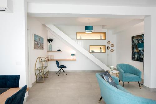a living room with blue chairs and a staircase at Candiano Palace in Portopalo