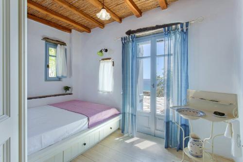 a bedroom with a bed and a glass door at Elayio Houses in Kardiani