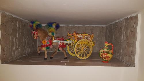 a figurine of a horse pulling a carriage with a vase at La Porta dell'Alcantara in Gaggi