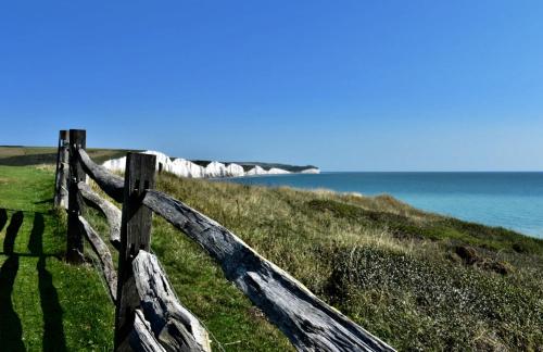 a wooden fence on the side of a beach at Sandford House Apartment in Seaford