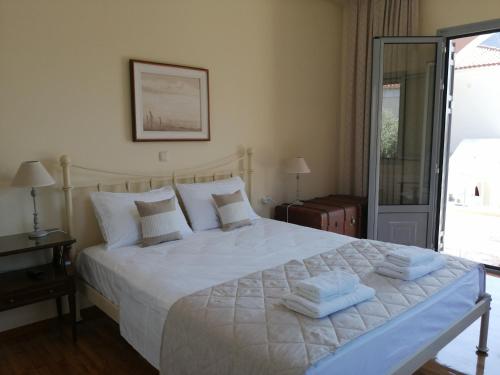 a bedroom with a large white bed with towels on it at New Garden's House (120m2) in Leonidion
