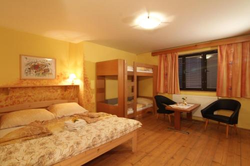 1 dormitorio con 1 cama, escritorio y sillas en Penzion Na Kopečku en Velké Karlovice