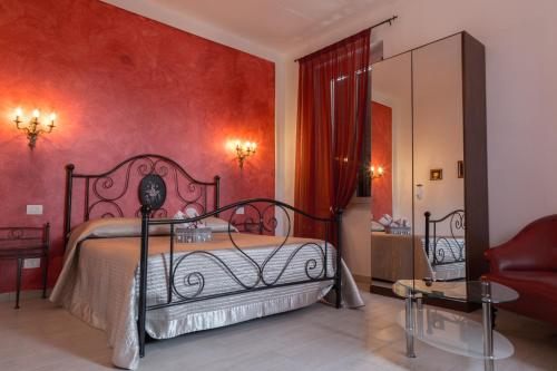 a bedroom with a bed and a red wall at C'era una volta appartamento Queen in Case Nuove