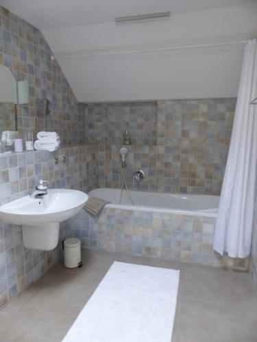 ein Badezimmer mit einem Waschbecken und einer Badewanne in der Unterkunft Prinz Ole in Haan
