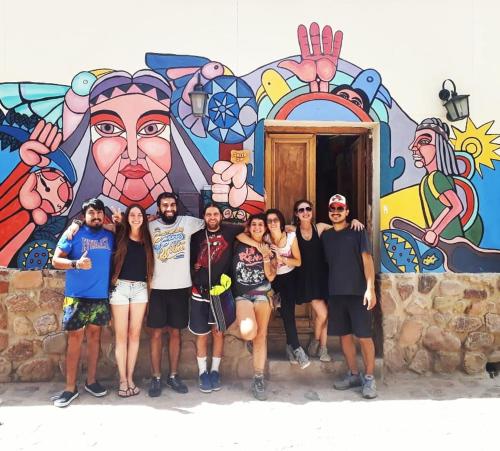 a crowd of people standing next to a wall at Giramundo Hostel in Humahuaca