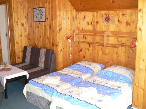 a bedroom with a bed and a chair and a table at Penzion Pstruh in Stožec