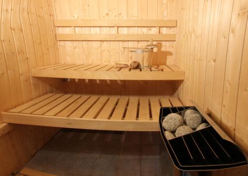 a wooden sauna with a basket of rocks in it at Penzion Na Kopečku in Velké Karlovice