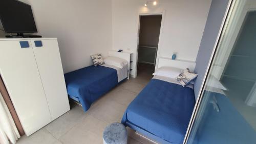 a small room with two beds and a television at Candiano Palace in Portopalo