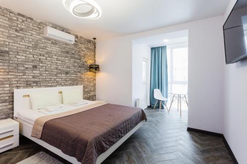 sypialnia z łóżkiem i ceglaną ścianą w obiekcie Апартаменти Герцена 35 w Kijowie