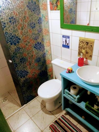 a bathroom with a toilet and a sink at CasaHostel Floresce in Praia do Rosa