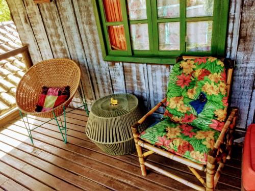 a room with a chair and two chairs and a window at CasaHostel Floresce in Praia do Rosa