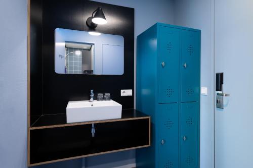 uma casa de banho com um lavatório e um espelho em Stayokay Hostel Terschelling em West-Terschelling