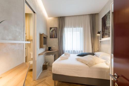 um quarto de hotel com uma cama e uma janela em Duomo Deluxe Room em Milão