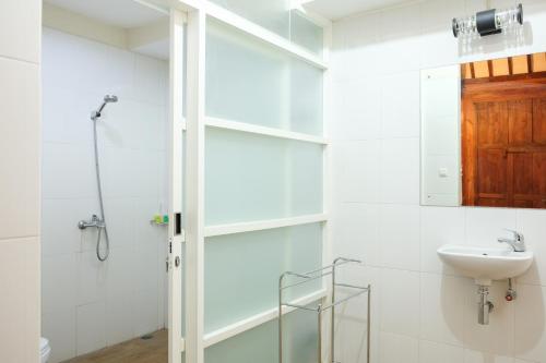 a bathroom with a sink and a shower at Pendhapa Art Space - PAS Limasan Homestay in Yogyakarta