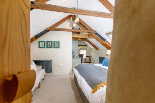 a bedroom with two beds in a room with exposed beams at Trewornan Manor in Wadebridge