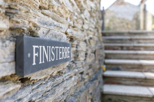 a sign on the side of a brick wall with stairs at Trewornan Manor in Wadebridge