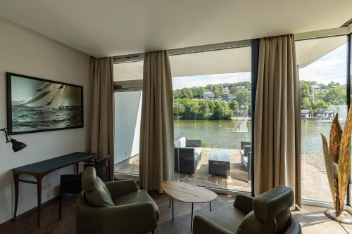 a living room with a view of a large window at MotelplusHotel BiggeSeeFront in Olpe