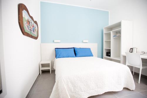 a white bedroom with a bed and a table and chairs at White Asses Rooms in Castellammare del Golfo