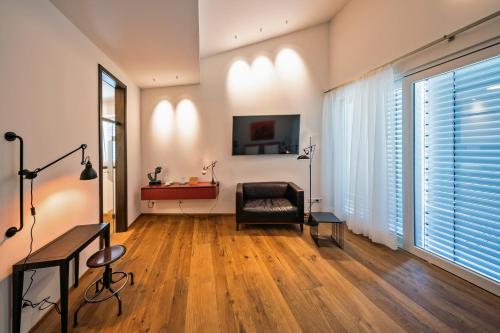 a living room with a chair and a television at MotelplusHotel BiggeSeeFront in Olpe