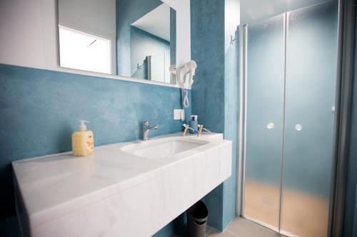 a bathroom with a white sink and a mirror at White Asses Rooms in Castellammare del Golfo