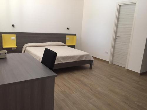 a bedroom with a bed and a desk in it at LE TORRI DEL CILENTO in Santa Maria di Castellabate