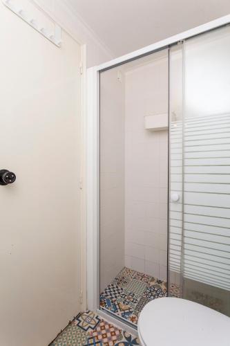 a shower with a glass door in a bathroom at SUPERNOVA Hostel in Porto