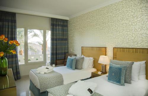 a hotel room with two beds and a window at Taba Sands Hotel & Casino - Adult Only in Taba