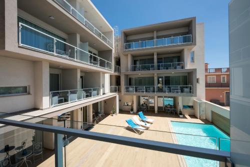 an apartment with a swimming pool and a balcony at Candiano Palace in Portopalo