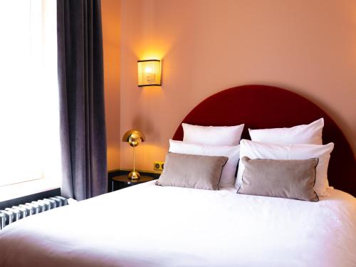 a bedroom with a large bed with white pillows at Hotel Mercure Roscoff Bord De Mer in Roscoff