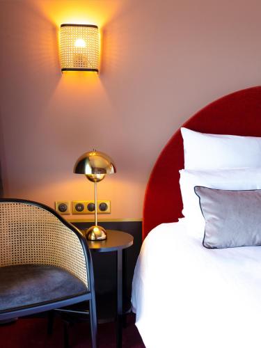 a hotel room with a bed and a chair at Hotel Mercure Roscoff Bord De Mer in Roscoff