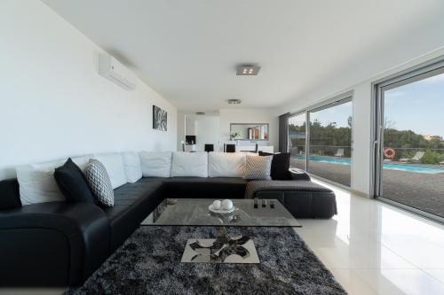 a living room with a black and white couch at Villa Panoramica II in Arco da Calheta