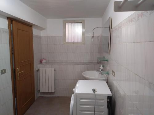 een witte badkamer met een wastafel en een toilet bij Fata dell'Etna in Pedara