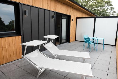 a patio with two tables and two chairs on a building at Armes de Champagne in Châlons-en-Champagne