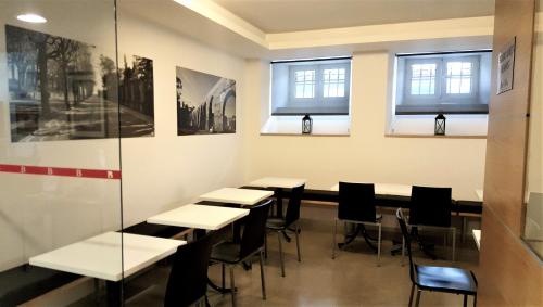 a room with tables and chairs and windows at Hotel Botanico de Coimbra in Coimbra