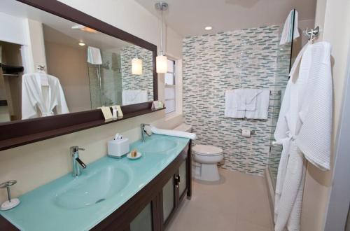 a bathroom with a sink and a toilet and a mirror at The Reefs Resort and Club in Southampton