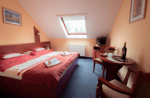 a bedroom with two beds and a table and a window at Boglárka Panzió - Étterem in Mezőkövesd