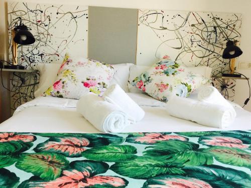 a bedroom with a bed with floral sheets and pillows at enZamorarte in Zamora