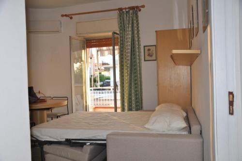 a bedroom with a bed and a table and a window at Taormina Mare Appartamento 300 Metri dal Mare in Giardini Naxos