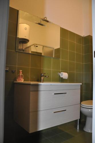 a bathroom with a sink and a mirror and a toilet at Taormina Mare Appartamento 300 Metri dal Mare in Giardini Naxos