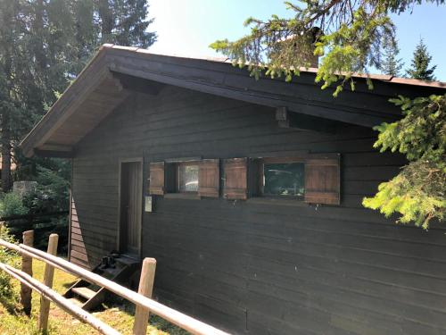 a black house with a window and a fence at Günther's Almhüttn in Arriach