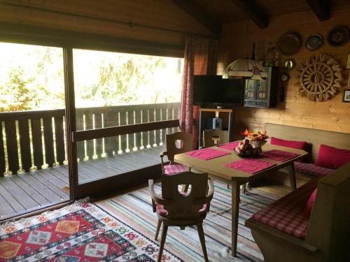a living room with a table and a balcony at Günther's Almhüttn in Arriach