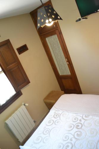 a bedroom with a bed and a wooden door at El Rincón del Oteru in Llanes