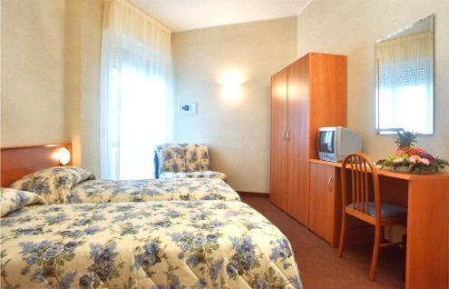 a hotel room with a bed and a desk with a tv at Hotel Engadina in Como